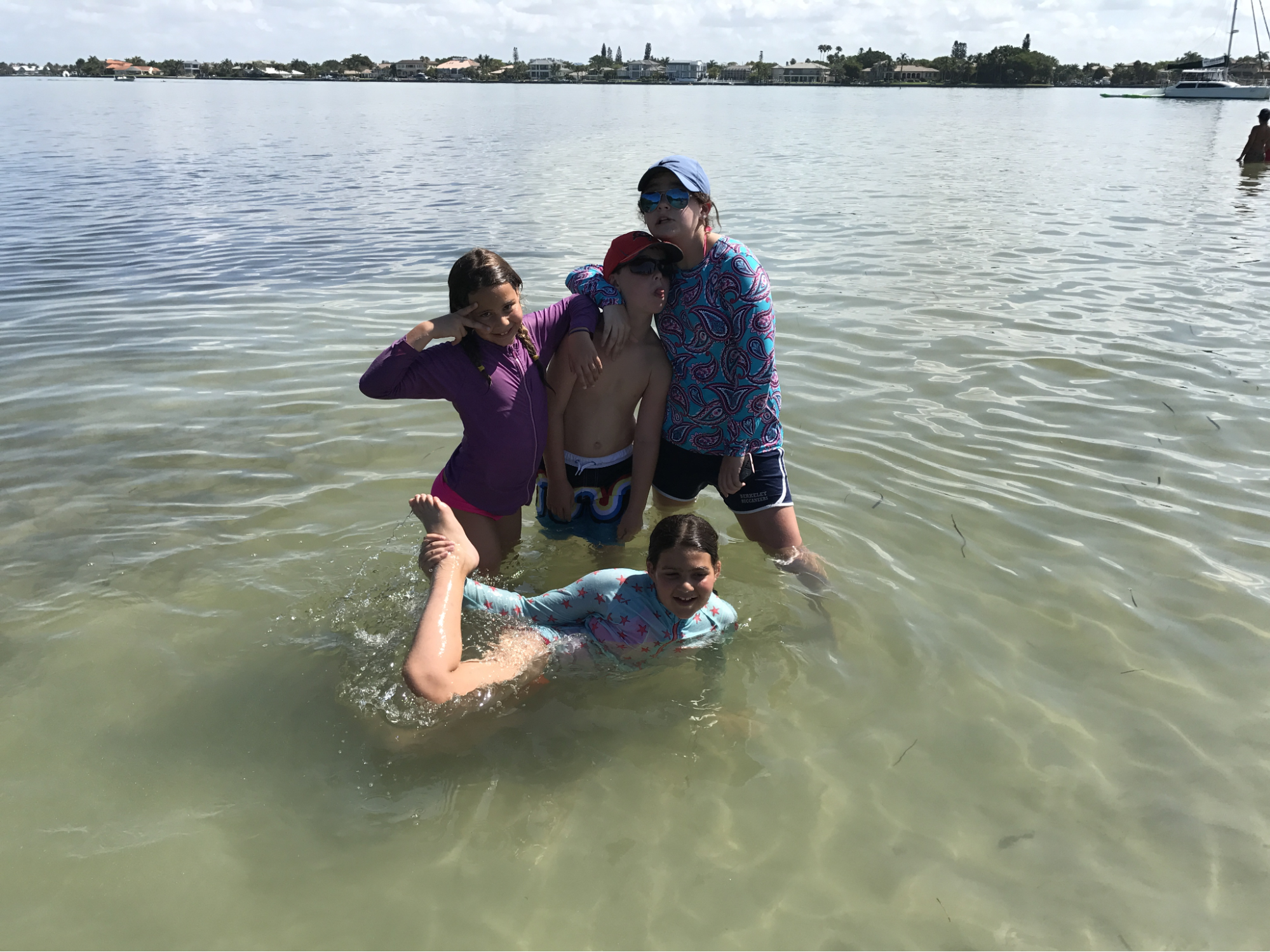A Paradise Adventures guide and four children having fun and splashing in the exceptionally calm and shallow waters of Sarasota Bay.